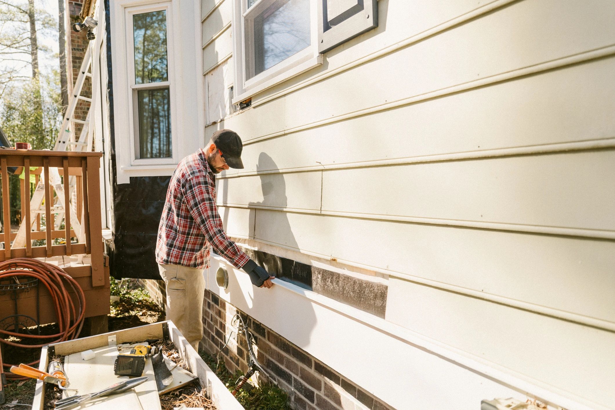 Technician performing exterior home improvement work